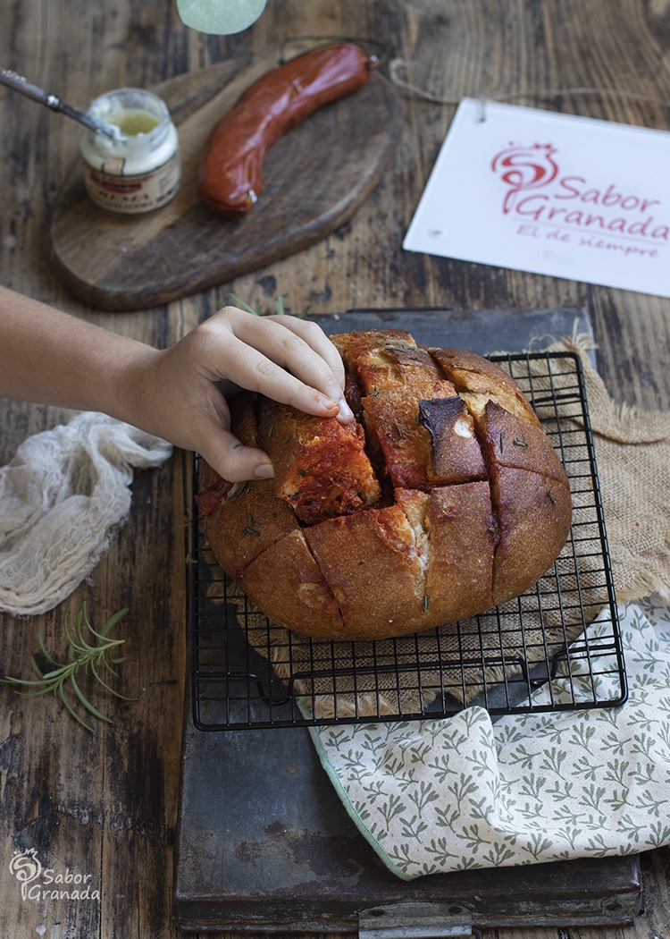 Cogiendo un trozo del pan al horno con crema de queso y sobrasada - Sabor Granada