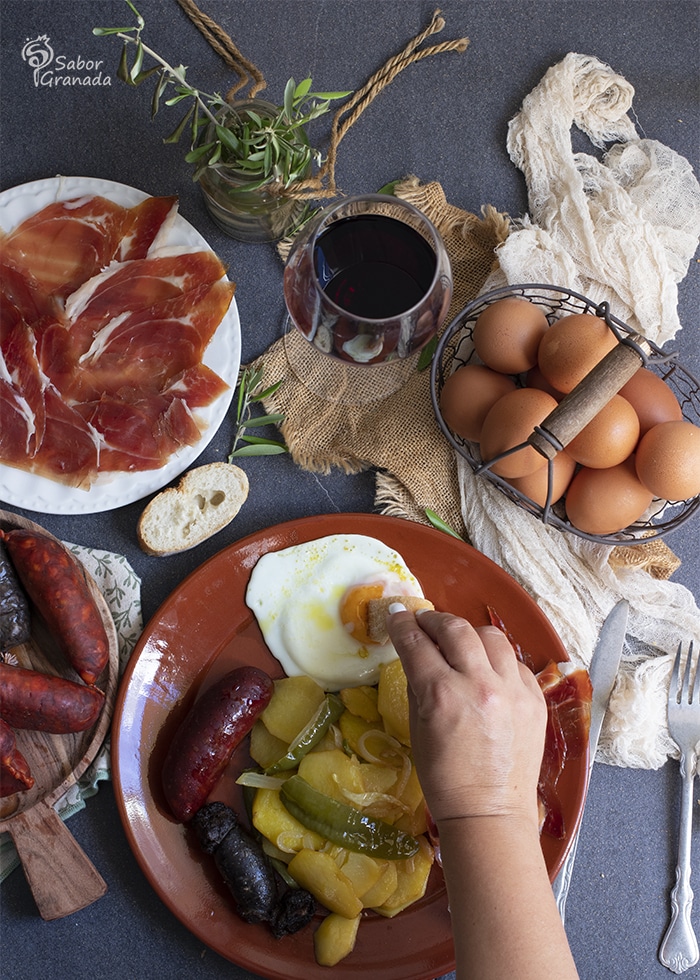 Mojando huevo en el plato Alpujarreño - Sabor Granada