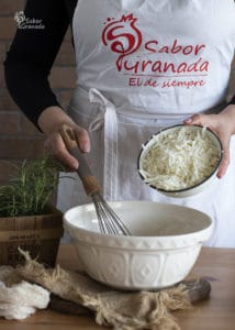 Cuarto paso de la receta de magdalenas de queso y romero: añadimos el queso - Sabor Granada