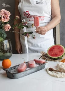 Uno de los polos de sandía y naranja en la mano - Sabor Granada